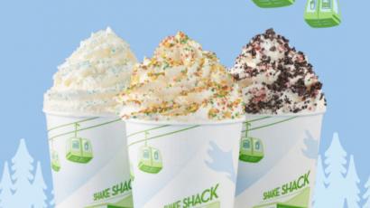three shakes with different toppings on them. In the background there are ski-lift icon in the air and tree outlines along the bottom.